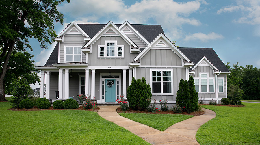 Two story home with light gray siding, white trim, and a covered front porch